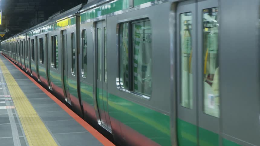 A subway train decelerates as it enters a platform