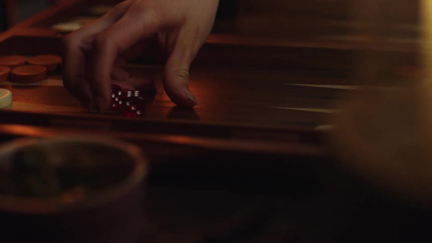 A person taking up dice from a board game