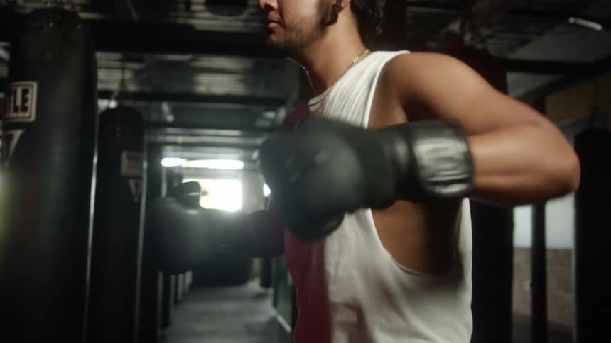 A boxer putting on gloves in a gym
