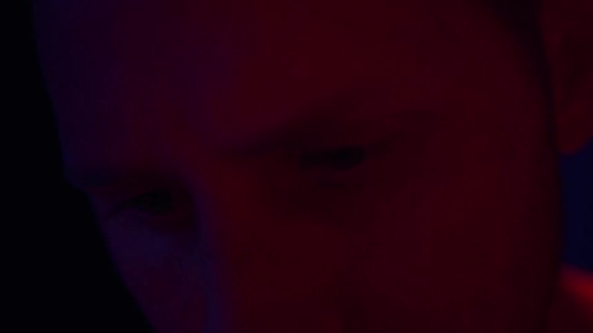 Red and blue lights reflecting on a mans face