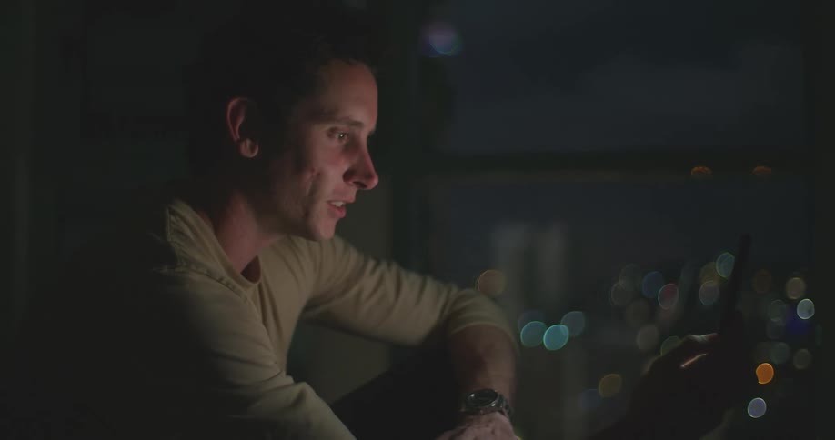 A man talking on a smartphone at night