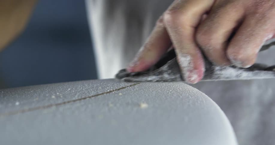 A man working on a surfboard