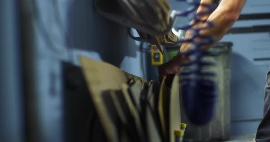 An employee grabbing cardboard from a stack