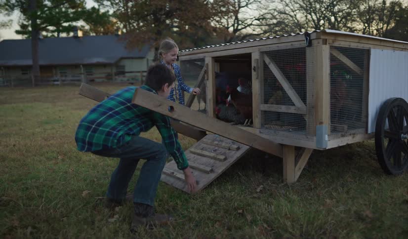 A brother and sister opening a chicken coop