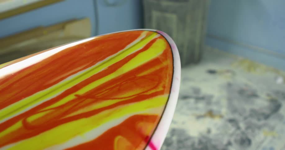 A surfboard has a colorful design