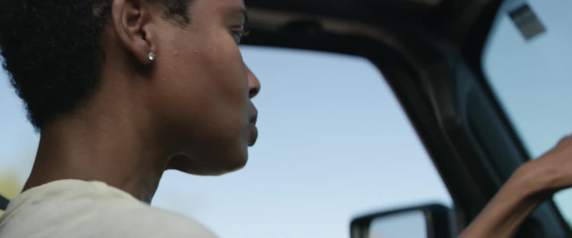 Sad and nervous woman dries tears from her face while driving