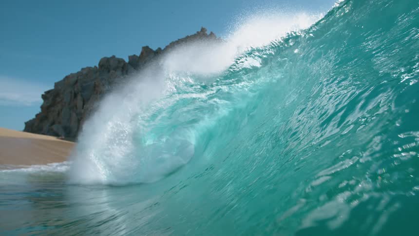 Big blue wave splashes and rolls overhead