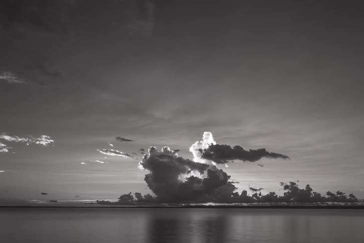 Open lake with clouds moving across a darkening sky