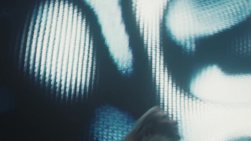 A woman dances as bright lights flash