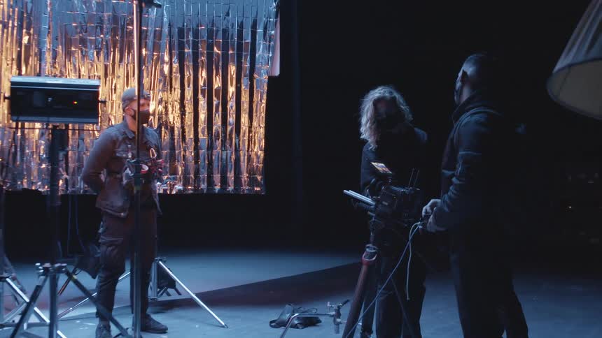 Film makers and photographers stand on a stage as light flash