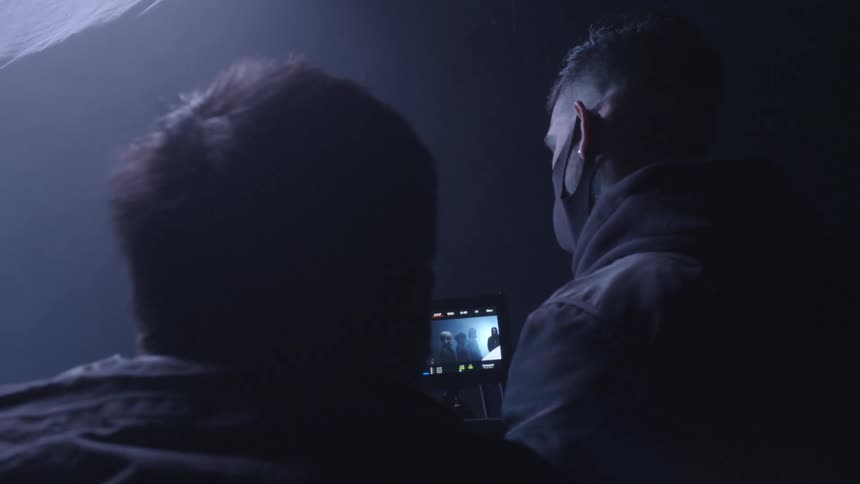 A man with a mask operating a camera