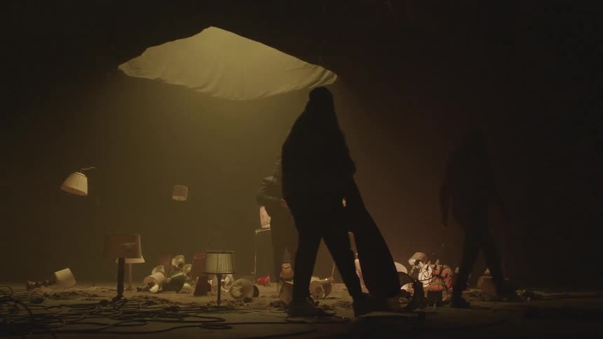 Three people in a room with flashing lamps on the floor
