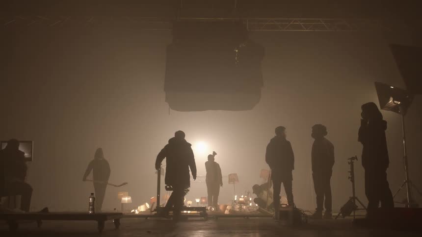 People are working on a foggy set