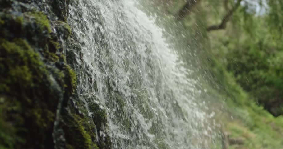 Close up static slow motion shot of water tumbling down a moss covered cliff face deep in Grand Canyon National Park in Arizona in the Southwest