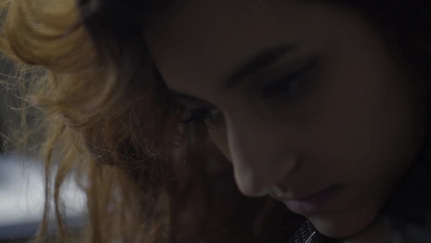A woman with red hair looks down