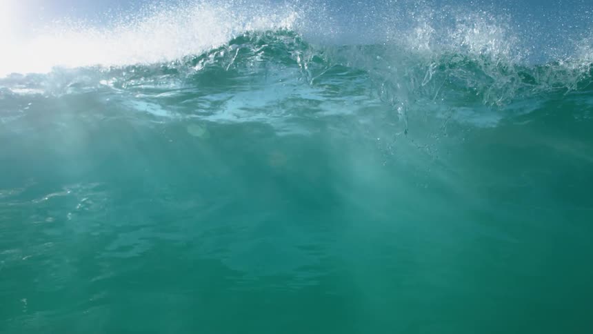 Big blue wave splashes and rolls overhead