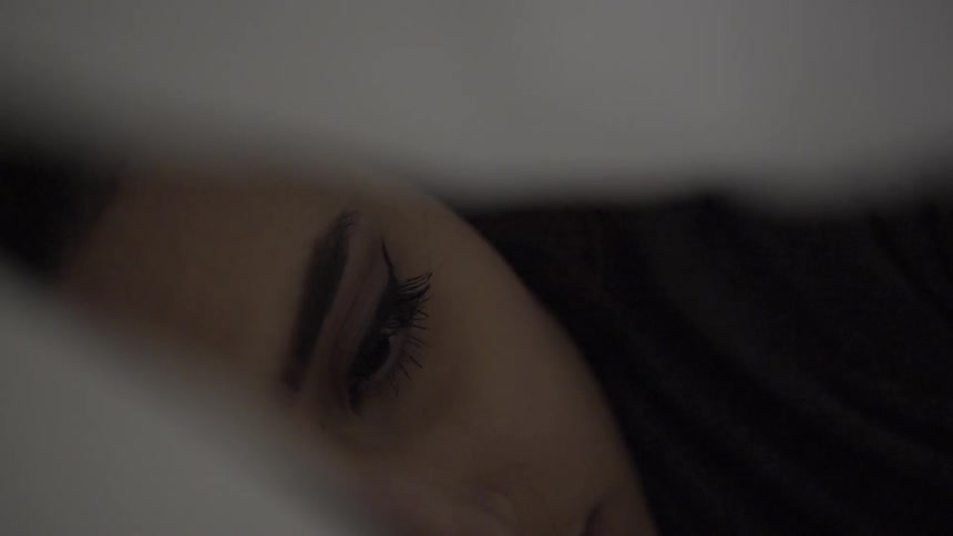 A blurry image of a sheet moving off a woman's head