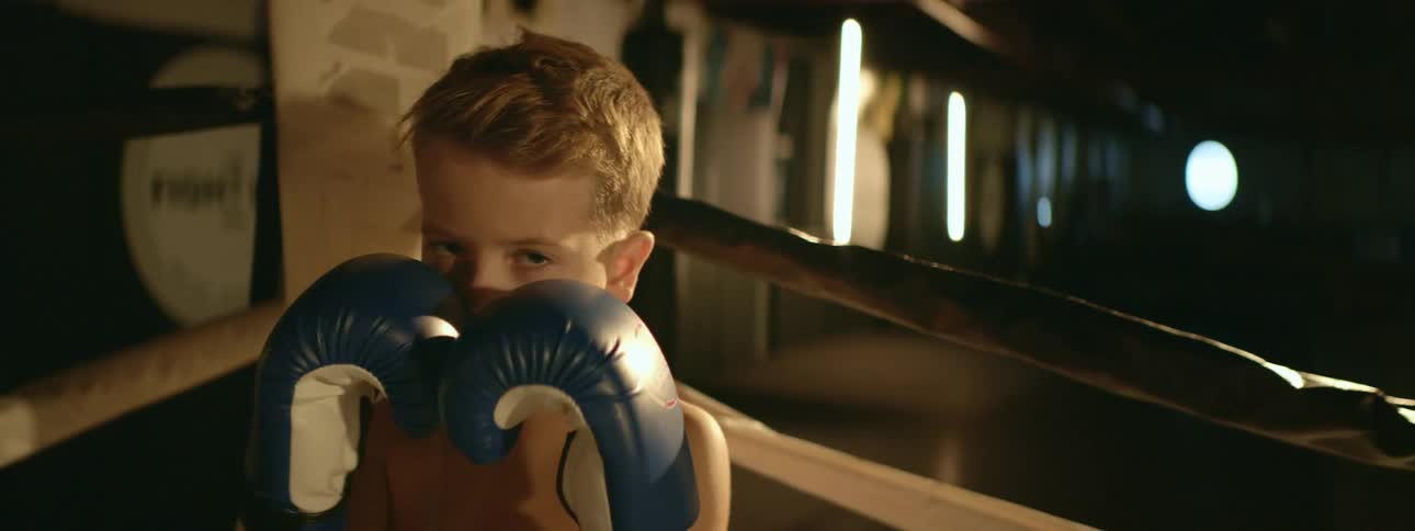 A child is boxing and wearing gloves