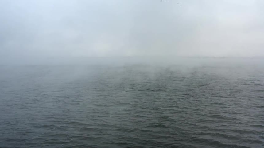 Mist floating above an ocean in the daytime