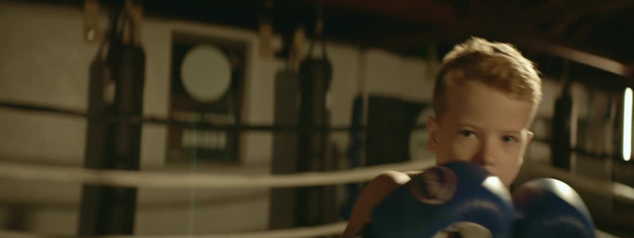 A child is boxing in a room indoors