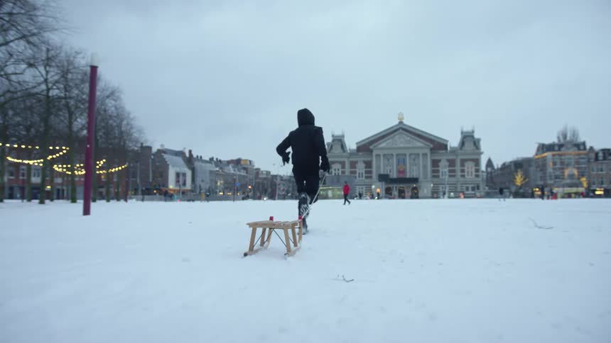 A person pulls a sleigh in the snow