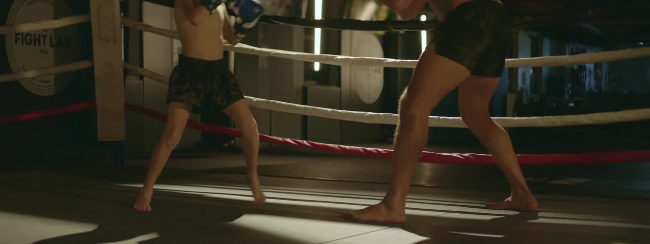 A person is teaching a kid how to box