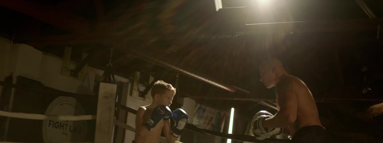 A man and a child boxing in a ring