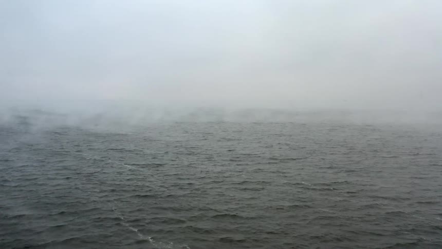 An aerial view of an ocean on a misty day