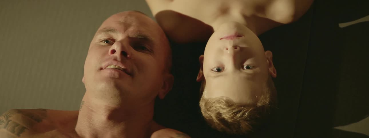 A father and son rest together on the floor