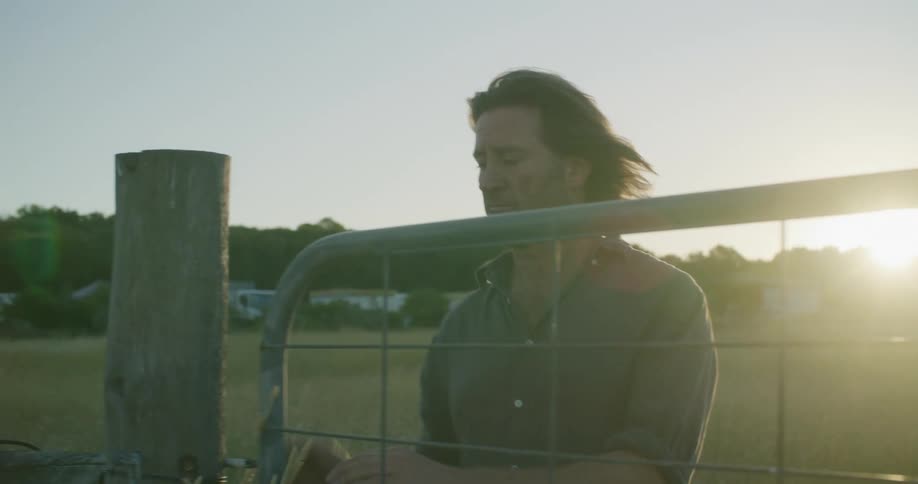 A man closes the gate on the farm