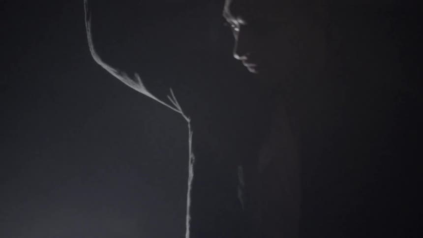 A man is moving around in a dark area
