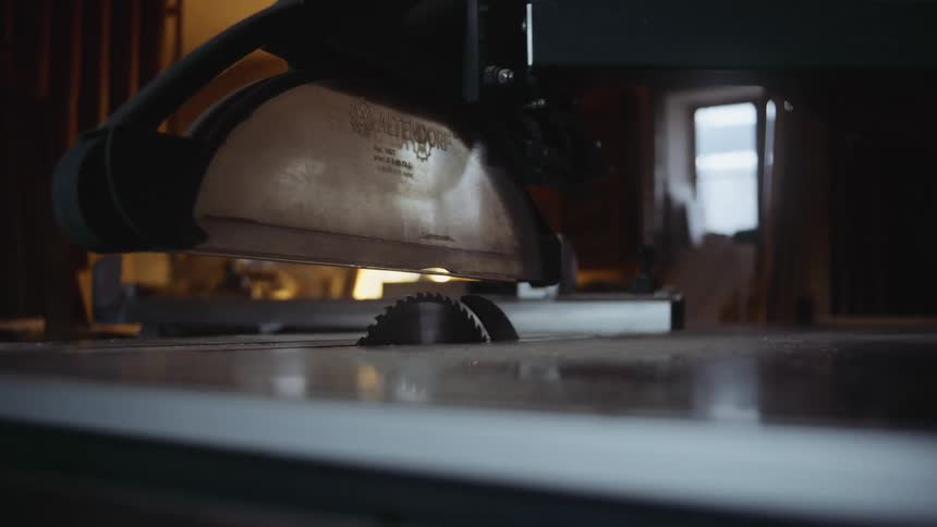 Table saw in dark room with lamp and a window in the background
