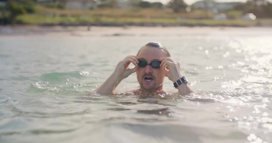 A man emerging from underwater while swimming in the ocean