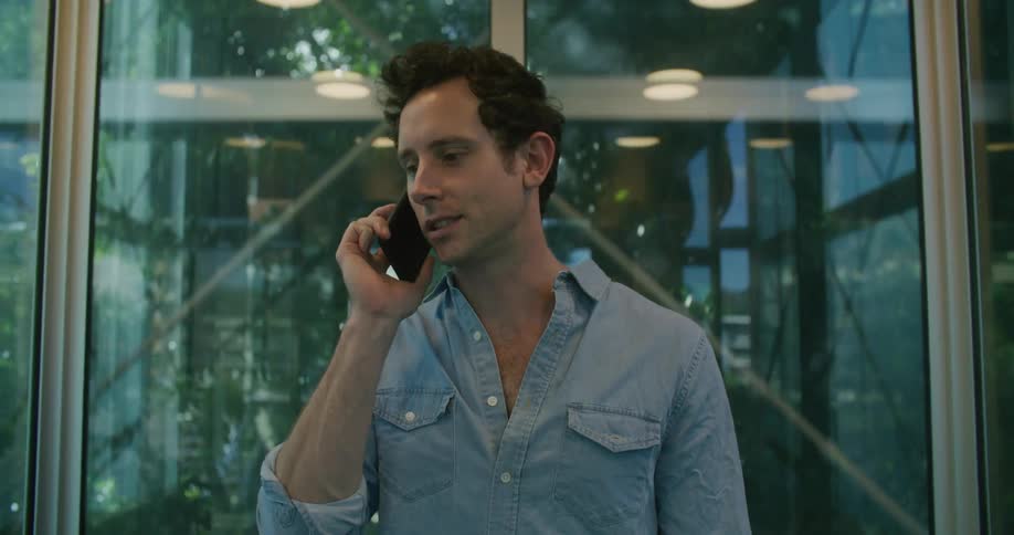 A man with a smart phone on an elevator