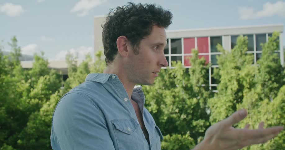 Two men are talking outdoors in a city during spring