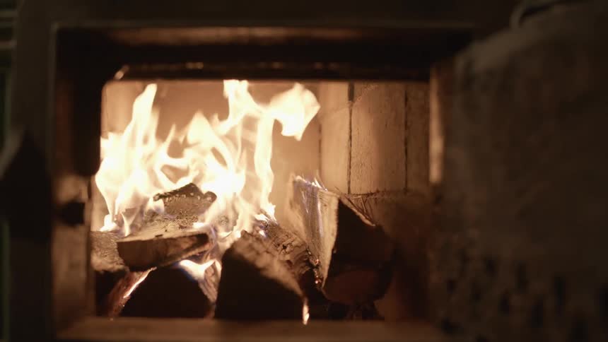 Wood being taken out of a fireplace in a home