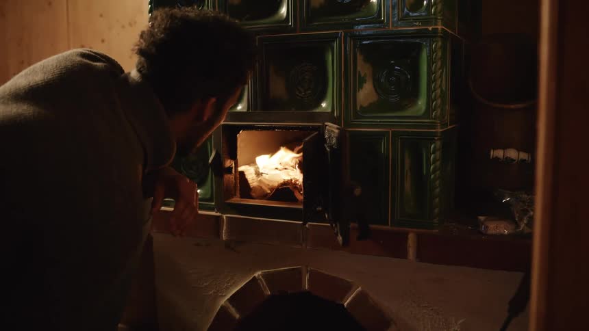 Man lights wood burning stove
