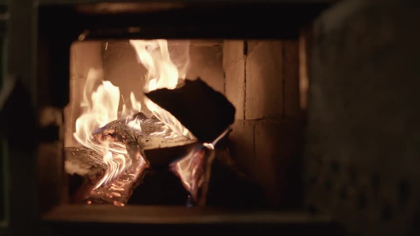 Fire logs burning in a fireplace with flames and embers