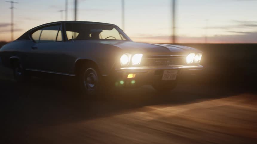 A vehicle is driving on the dirt road at sunset