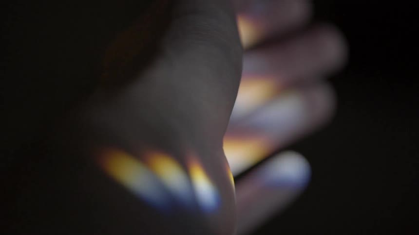 Prism light reflects on a person's arm