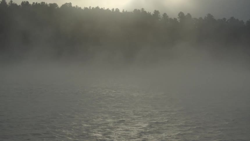 Fog rises over a lake in the morning