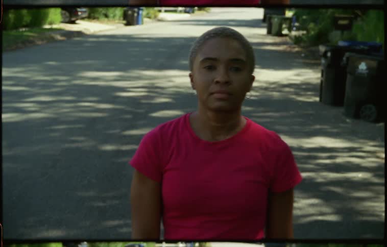 A woman is walking down the street in the neighborhood