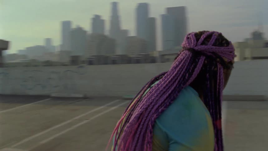 A woman is dancing outdoors in a city