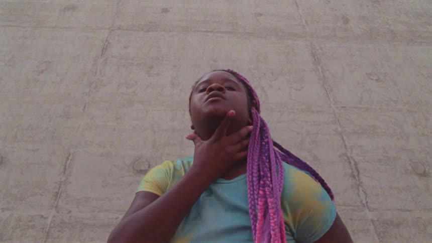 A woman with dreadlocks is dancing outside