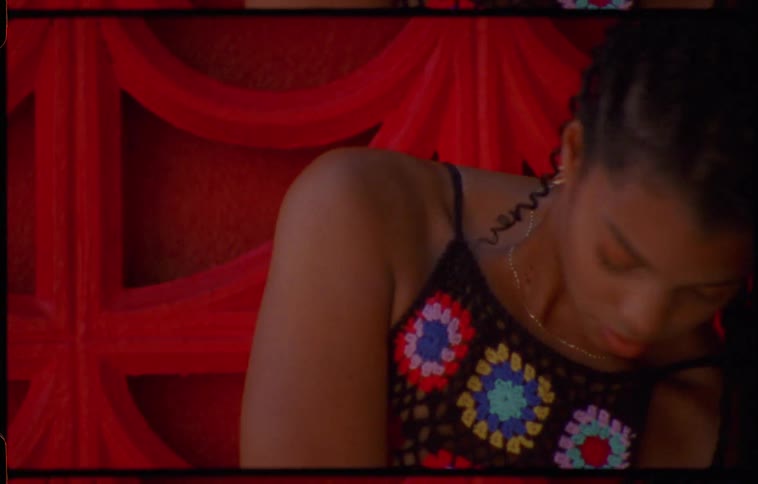 Young long haired woman energetically dancing in front of a red wall