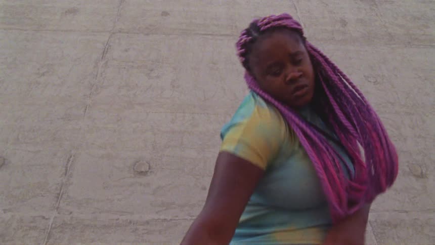 A woman is waving around as she dances outside