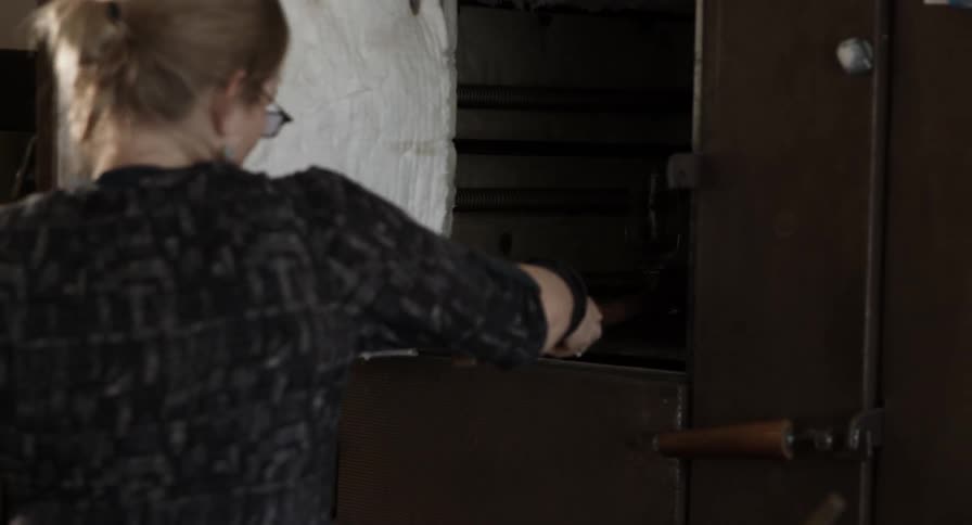 A woman places a glass in a cooling cabin