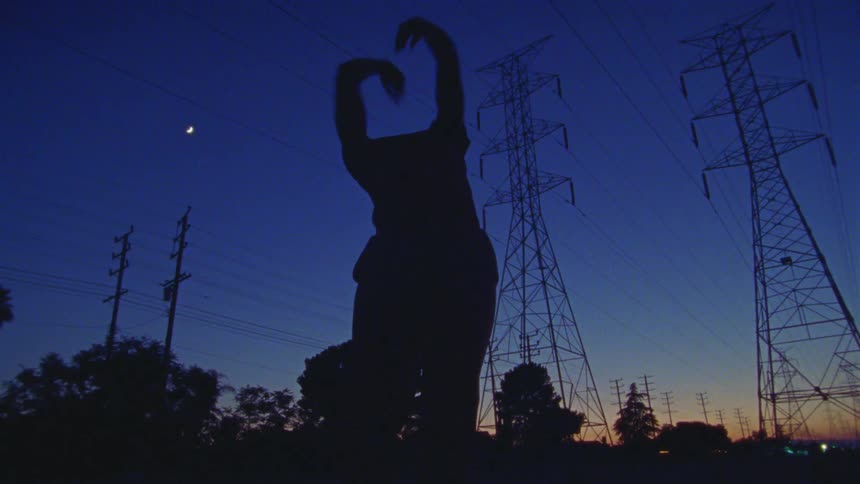 A person dances outside under the moon
