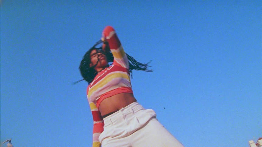 A woman dancing around outside on a sunny day