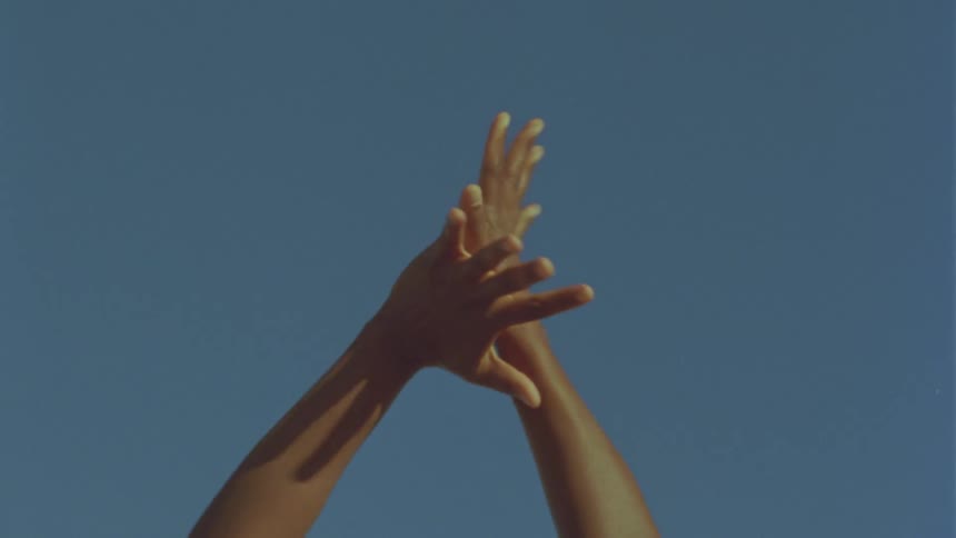 A person stretching their hands with the sky in the background